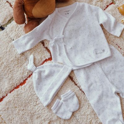 Set primera puesta unisex en color blanco con camiseta cruzada, polaina, gorro y manoplas para recién nacido