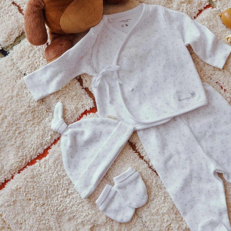 Set primera puesta unisex en color blanco con camiseta cruzada, polaina, gorro y manoplas para recién nacido